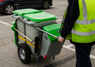 Chariot de voirie poubelle Double en vert avec pince à déchets dans un parking