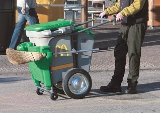 Chariot de voirie Double vert avec pince à déchets à l'extérieur parking de McDonalds
