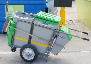 Chariot de voirie Double vert avec pince à déchets dans un environnement industriel