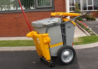 Chariot de voirie Simple™ jaune avec pince à déchets en usage