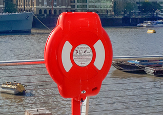Coffre a bouée Guardian™ avec un rouge couvercle à l'extérieur d’une entreprise de maritime