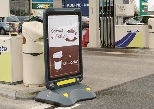 Stop trottoir Advocate™ panneau d'affichage sur pied dehors d’une station-service