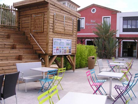 Poubelle urbaine avec couvercle Sherwood par table au camping Les Mediterranees Beach Garden